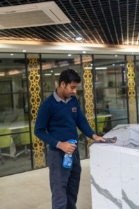CAS Facilities cleaner disinfecting a modern office reception counter